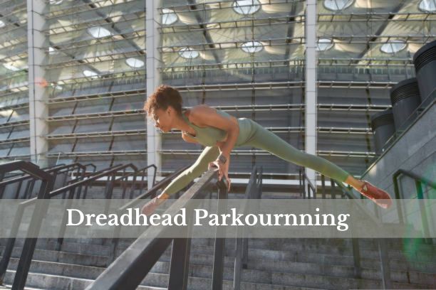 Dreadhead Parkour athlete performing a gravity-defying wall run in an urban setting.